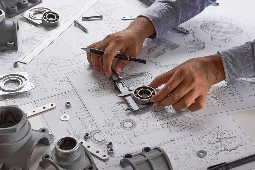 Engineer checking foundry pattern dimensions against a technical drawing